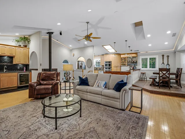a living room with furniture kitchen view and a chandelier