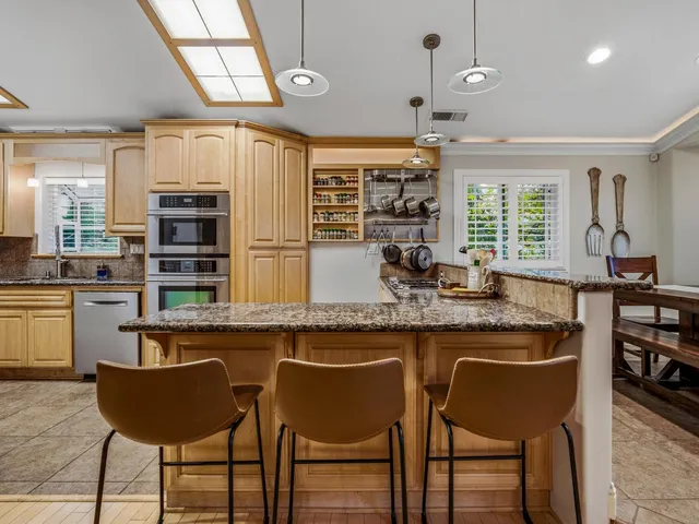 a kitchen with a table chairs sink and cabinets
