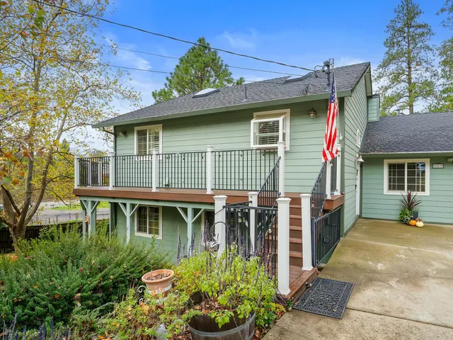a front view of a house with a yard and potted plants