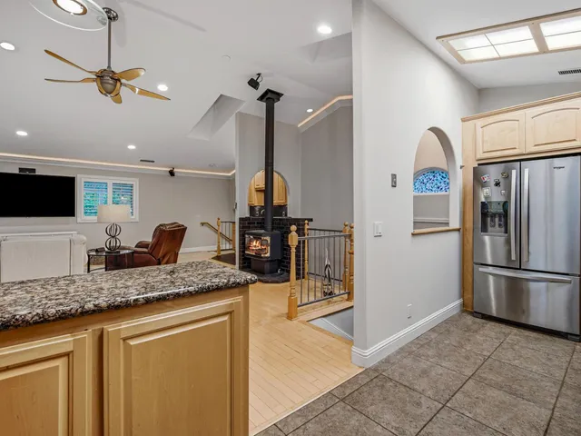 a kitchen with stainless steel appliances granite countertop a sink refrigerator and cabinets