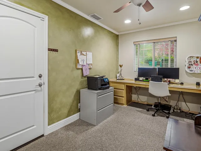 a view of a workspace with furniture and a window