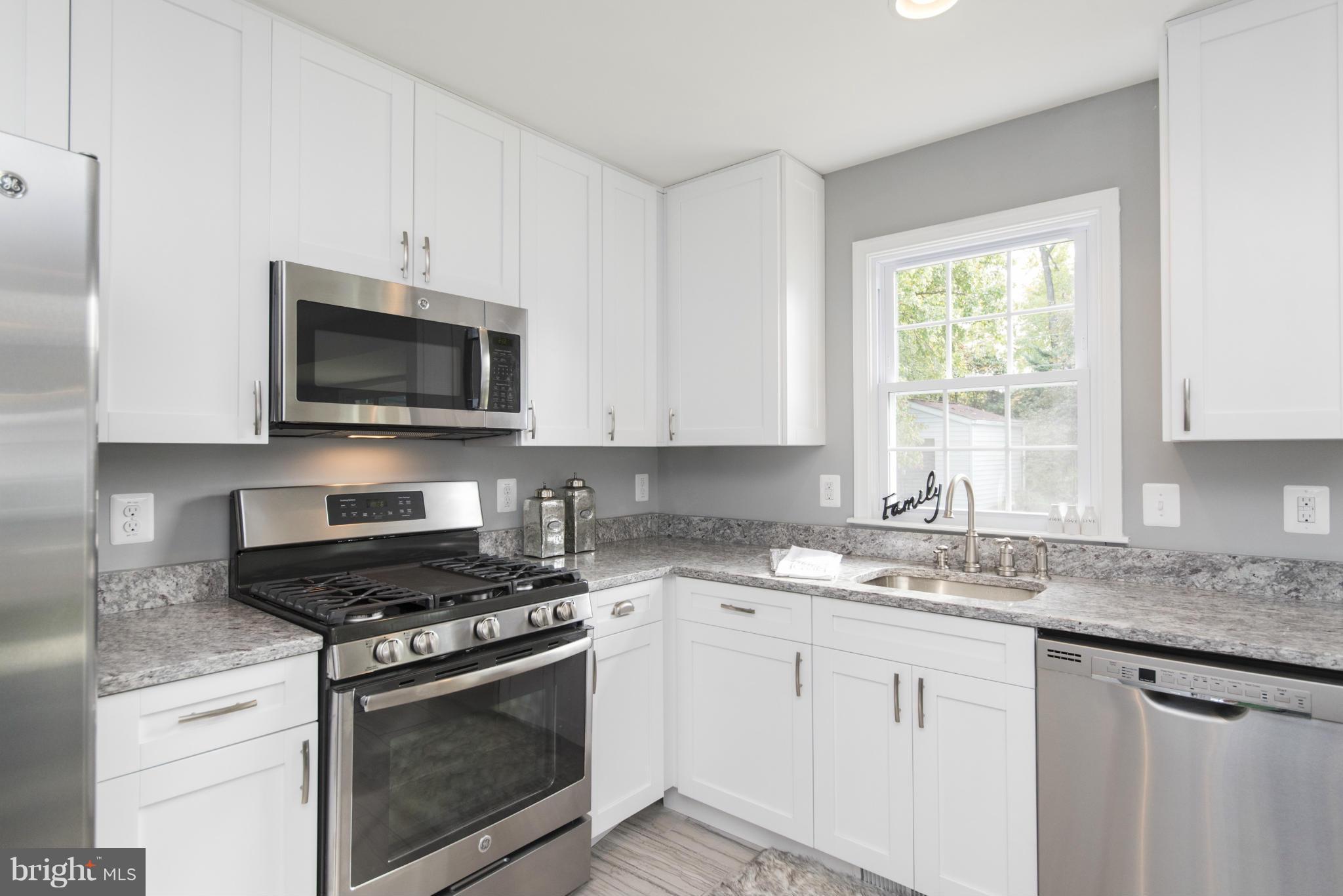 6705 Fordcrest Road Baltimore, MD 21237 - Photo 1 of 30 a kitchen with granite countertop a sink cabinets stainless steel appliances and a window