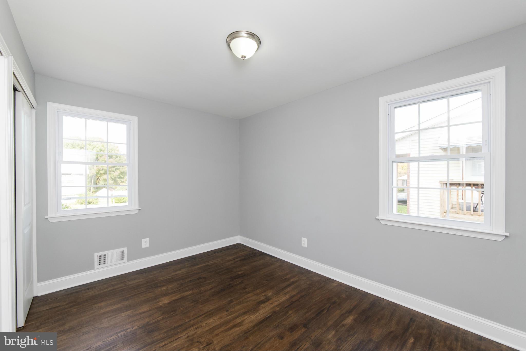 6705 Fordcrest Road Baltimore, MD 21237 - Photo 19 of 30 an empty room with wooden floor and windows