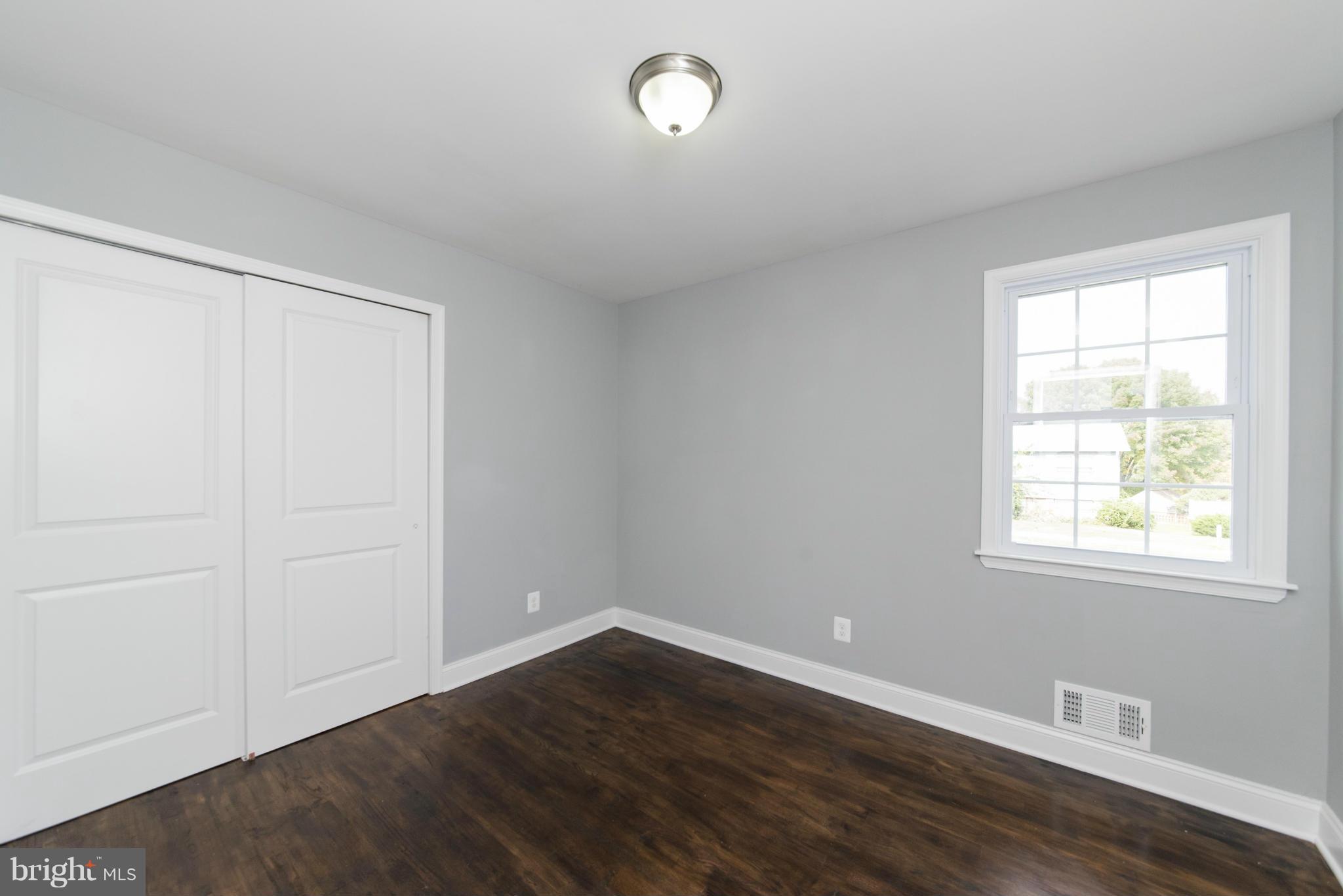6705 Fordcrest Road Baltimore, MD 21237 - Photo 22 of 30 an empty room with wooden floor and windows