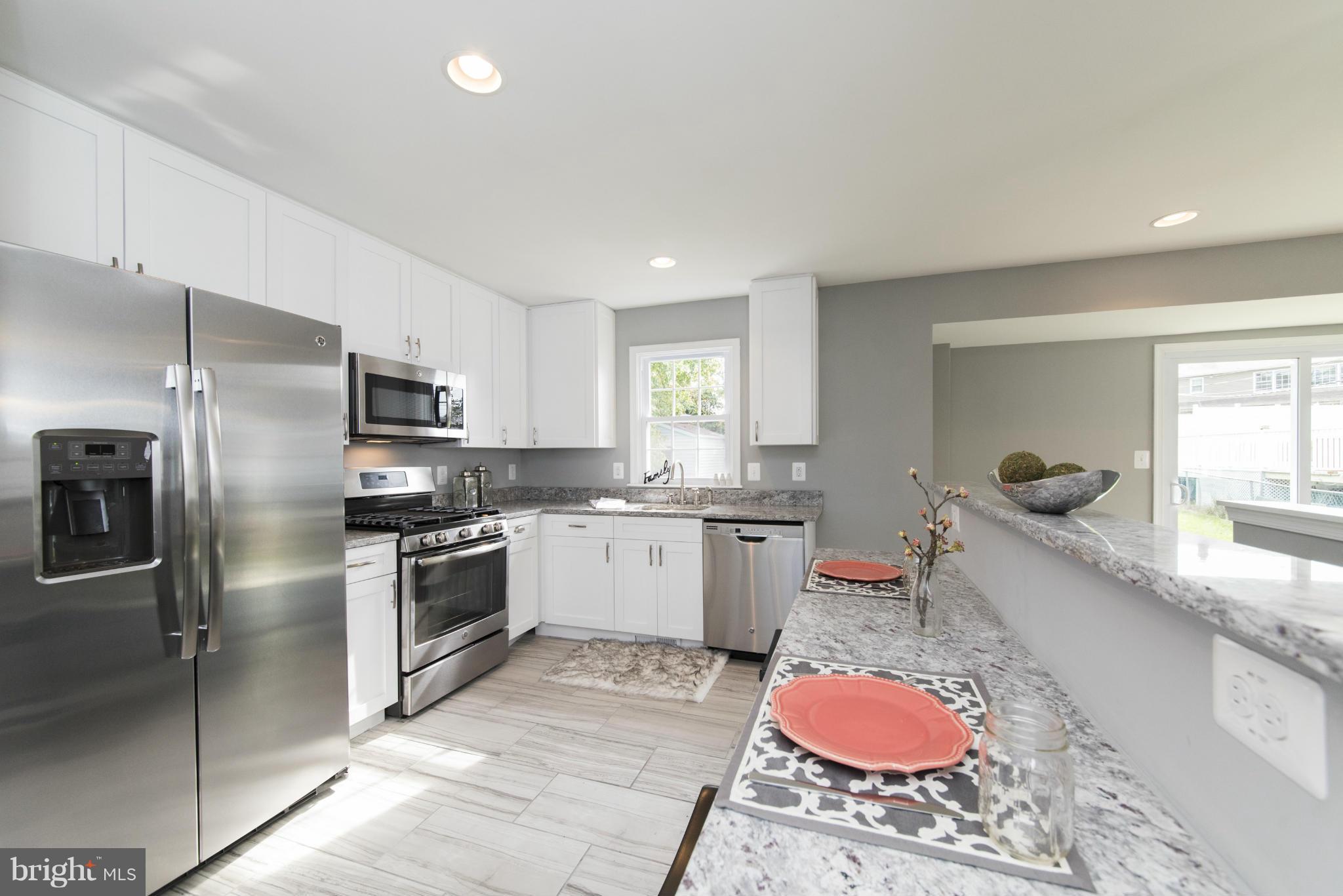 6705 Fordcrest Road Baltimore, MD 21237 - Photo 5 of 30 a kitchen with stainless steel appliances granite countertop a sink dishwasher stove refrigerator and microwave