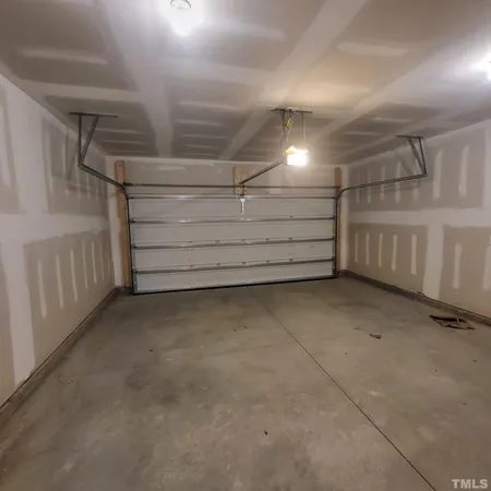 a big yard with large trees and cars parked in the background