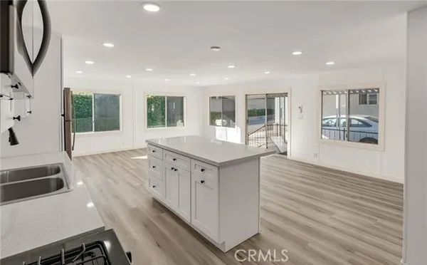 a kitchen with kitchen island a sink stainless steel appliances and refrigerator