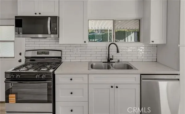 a view of a kitchen with a refrigerator and wooden floor