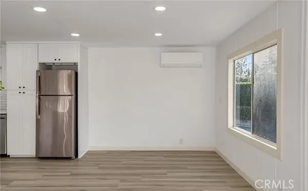 a view of a hallway with wooden floor and closet area
