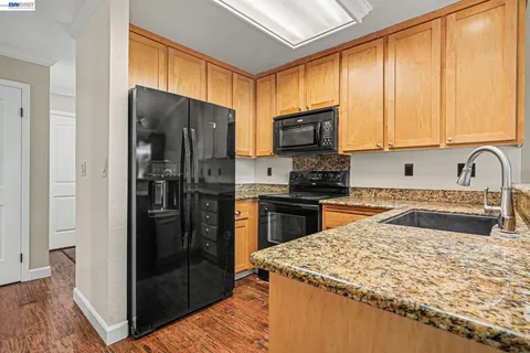 a kitchen with a refrigerator a microwave a sink and cabinets