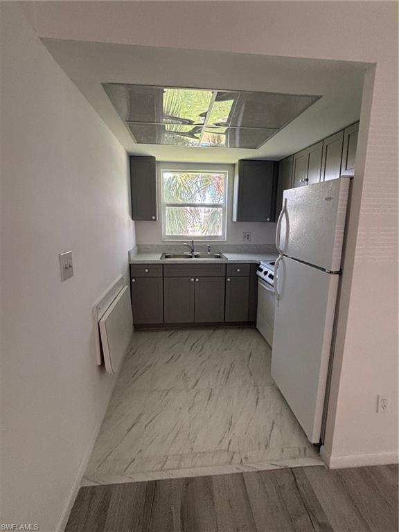 3250 10th Street North, Unit A8 Naples, FL 34103 - Photo 3 of 13 a kitchen with stainless steel appliances granite countertop a refrigerator and a sink