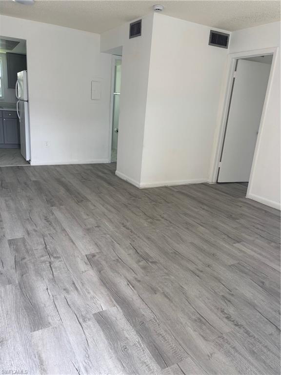 3250 10th Street North, Unit A8 Naples, FL 34103 - Photo 6 of 13 an empty room with wooden floor