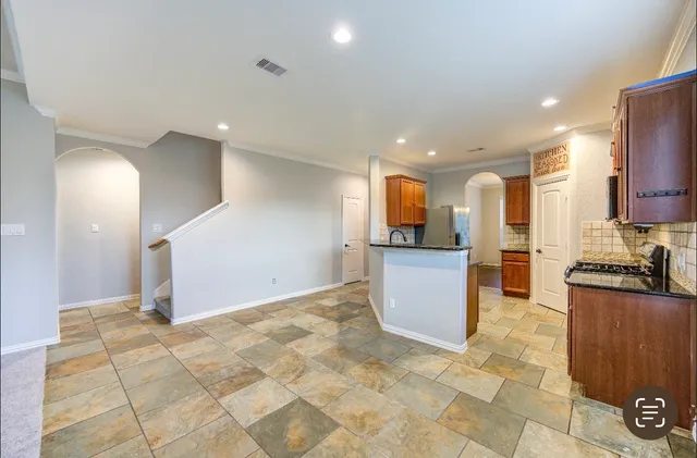 a kitchen with stainless steel appliances granite countertop a stove a sink and a microwave