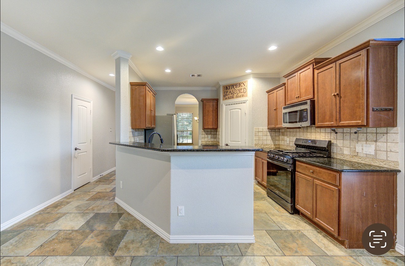 7 Maple Mill Court Conroe, TX 77301 - Photo 13 of 49 a kitchen with stainless steel appliances granite countertop a stove a sink and a microwave
