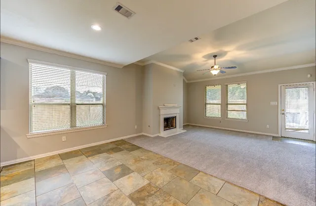 a view of an empty room with window and fireplace