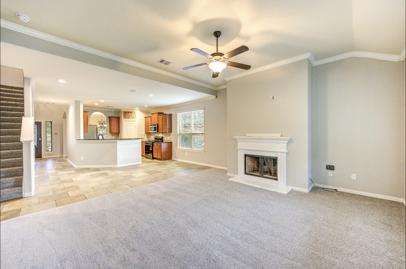 7 Maple Mill Court Conroe, TX 77301 - Photo 18 of 49 a view of a livingroom with a fireplace and a ceiling fan