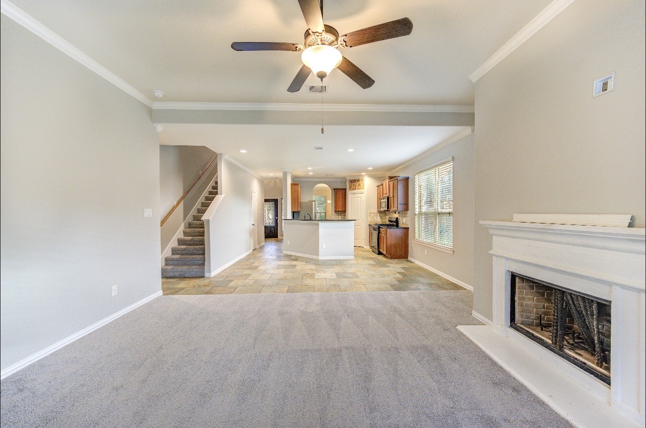 7 Maple Mill Court Conroe, TX 77301 - Photo 19 of 49 a view of a livingroom with a fireplace and chandelier fan