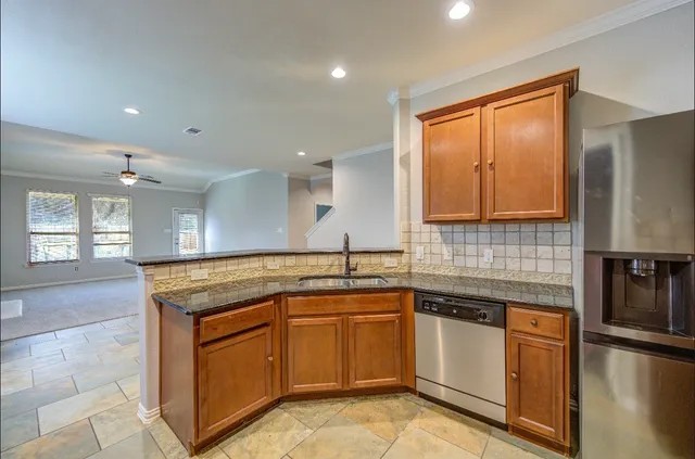a kitchen with stainless steel appliances granite countertop a sink stove and cabinets