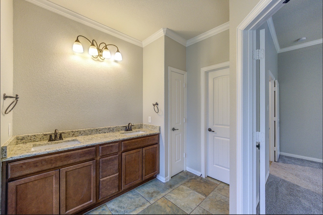 7 Maple Mill Court Conroe, TX 77301 - Photo 29 of 49 a bathroom with a double vanity sink and a mirror