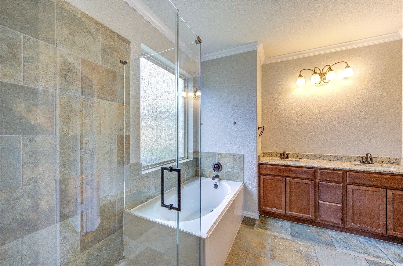 7 Maple Mill Court Conroe, TX 77301 - Photo 34 of 49 a bathroom with a tub sink and mirror