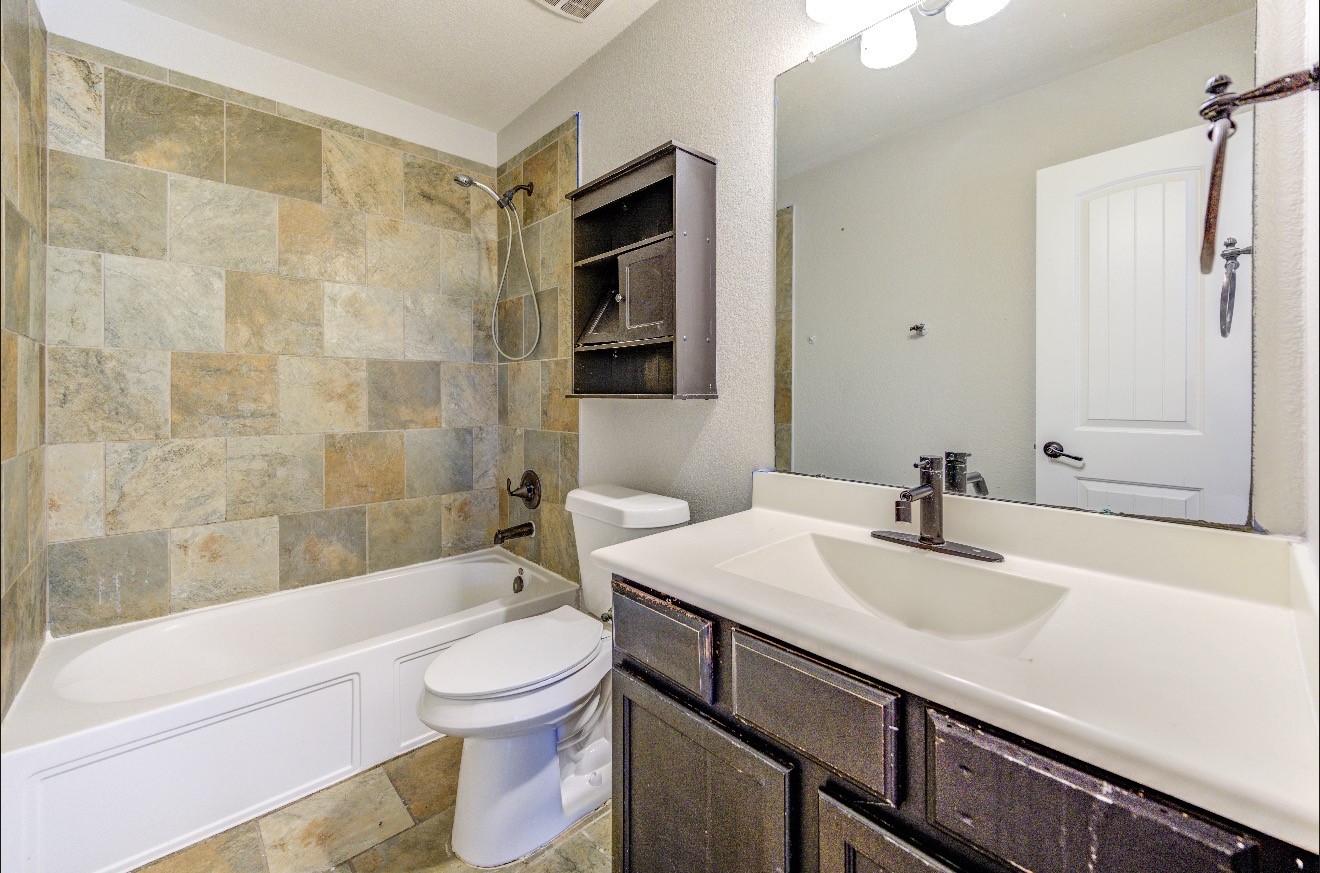 7 Maple Mill Court Conroe, TX 77301 - Photo 46 of 49 a bathroom with a sink a toilet and shower