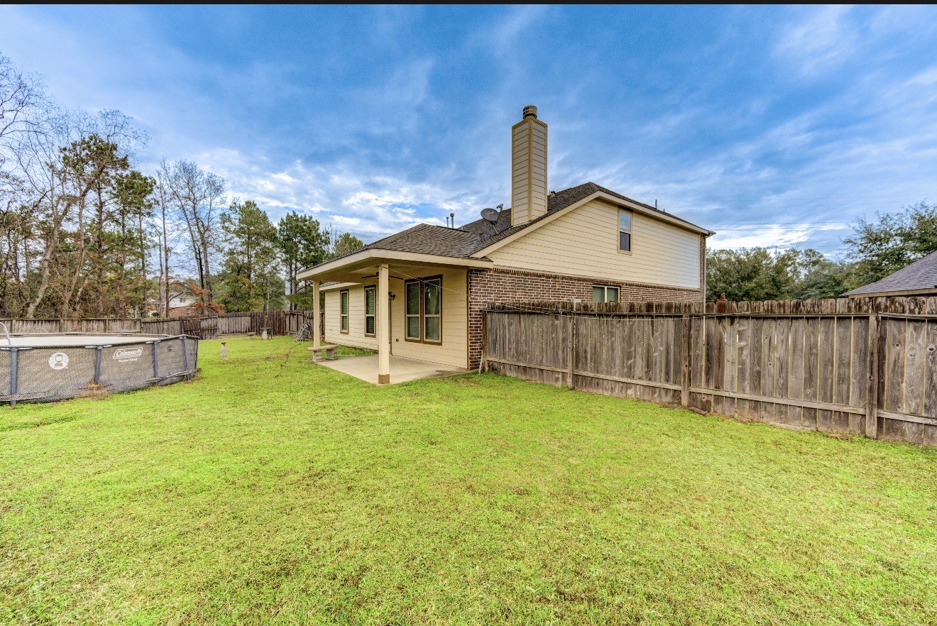 7 Maple Mill Court Conroe, TX 77301 - Photo 47 of 49 a front view of a house with a garden and yard
