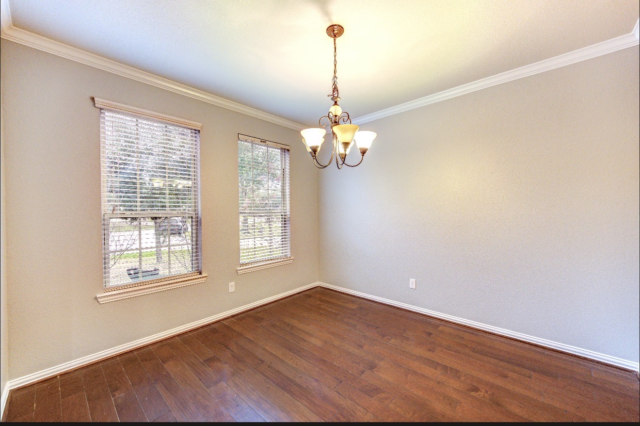 7 Maple Mill Court Conroe, TX 77301 - Photo 8 of 49 wooden floor in an empty room with a window