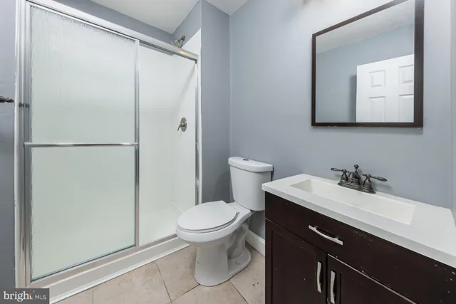 a bathroom with a toilet sink vanity and mirror