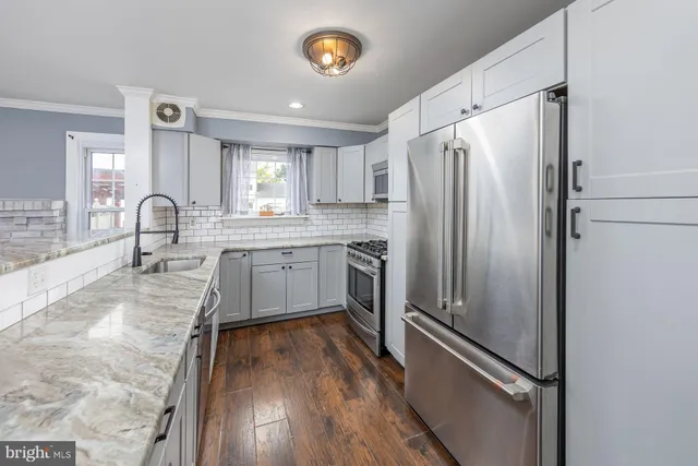 a kitchen with granite countertop stainless steel appliances a refrigerator sink and cabinets