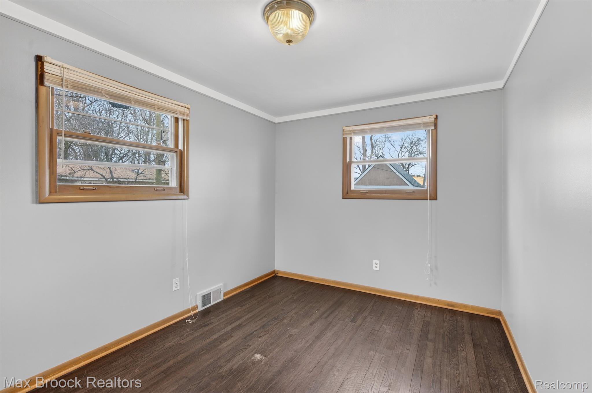 9024 Mandon Road White Lake, MI 48386 - Photo 18 of 39 Empty room with dark wood-type flooring and ornamental molding