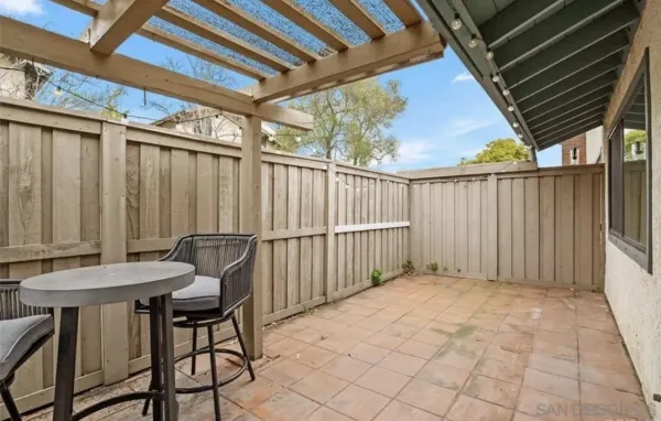 a view of a backyard with furniture and iron fence