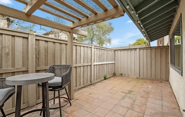 a view of a backyard with furniture and iron fence