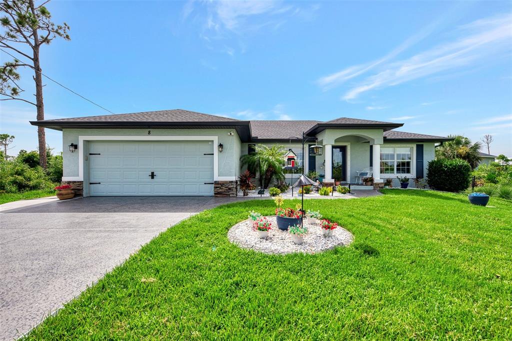 8 Amidship Road Placida, FL 33946 - Photo 2 of 47 a front view of a house with a yard fire pit and large tree