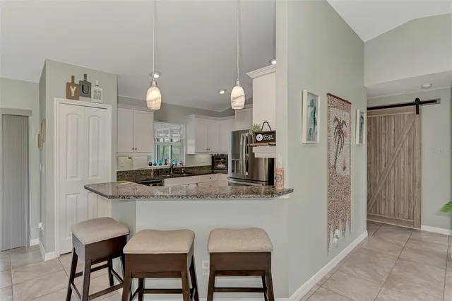 a kitchen with stainless steel appliances granite countertop a sink and a refrigerator