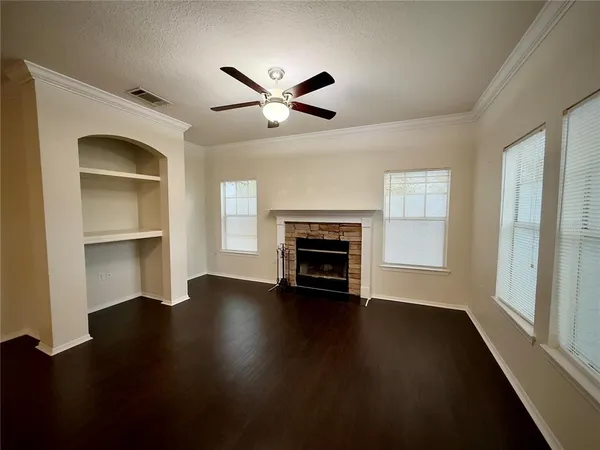 a view of an empty room with window and wooden floor