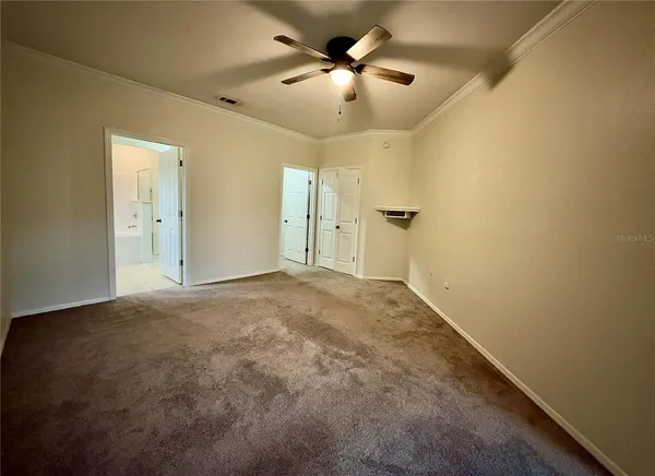 an empty room with a ceiling fan and a window