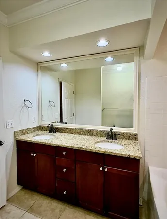 a bathroom with a granite countertop sink a large mirror and a shower