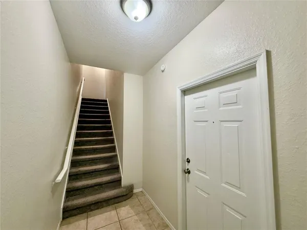 a view of a hallway with stairs and wooden floor