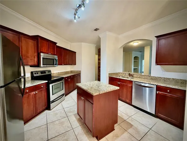 a kitchen with stainless steel appliances granite countertop a stove refrigerator and a sink