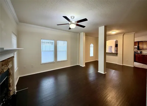 a view of an empty room with wooden floor and a fireplace