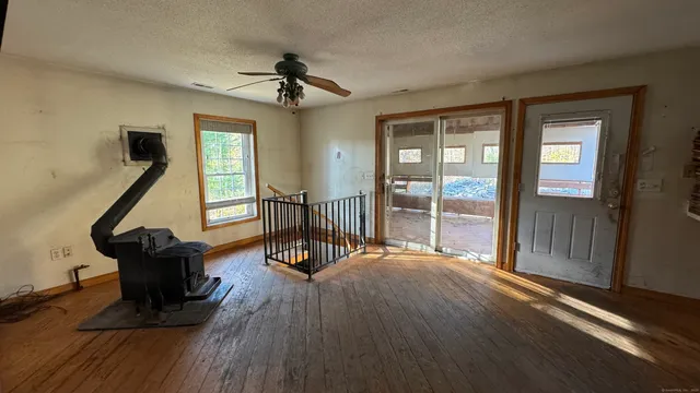a view of a room with wooden floor windows and a ceiling fan
