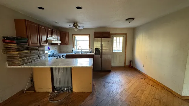 a kitchen with kitchen island granite countertop a sink cabinets and wooden floor