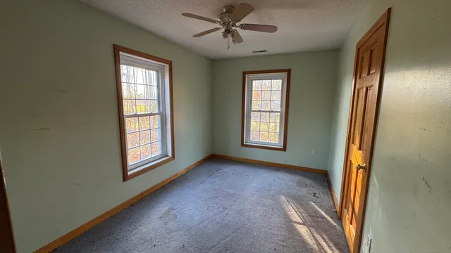 an empty room with windows and closet