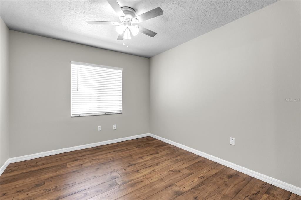 1424 Ocean Reef Road Wesley Chapel, FL 33544 - Photo 18 of 47 wooden floor in an empty room with a window