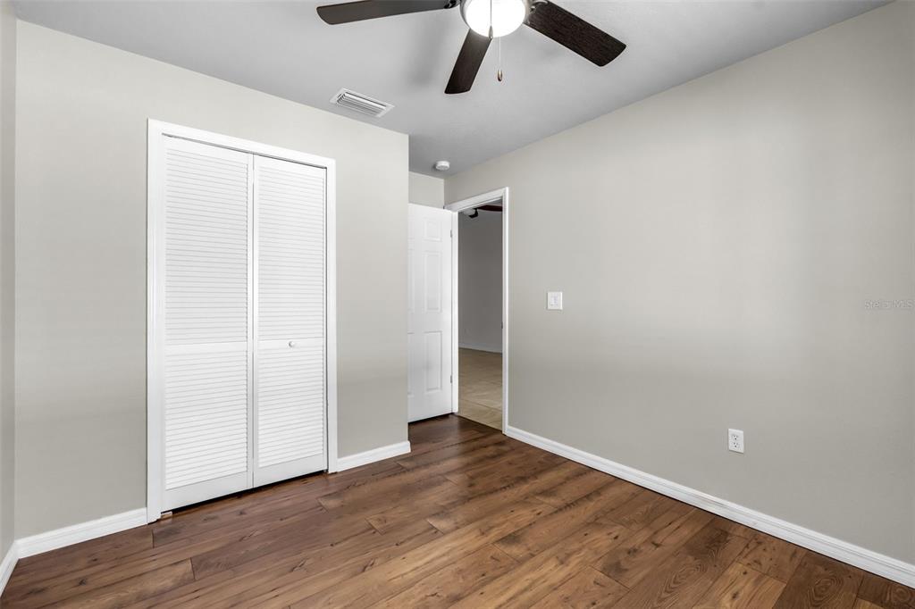 1424 Ocean Reef Road Wesley Chapel, FL 33544 - Photo 22 of 47 an empty room with wooden floor and windows