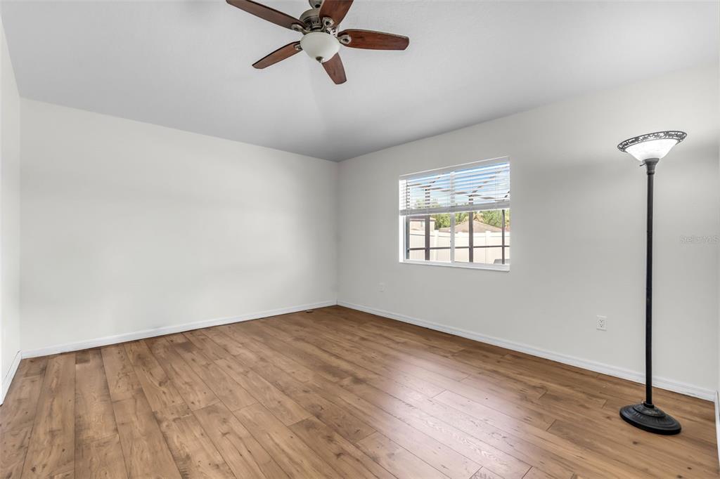 1424 Ocean Reef Road Wesley Chapel, FL 33544 - Photo 23 of 47 an empty room with wooden floor fan and windows