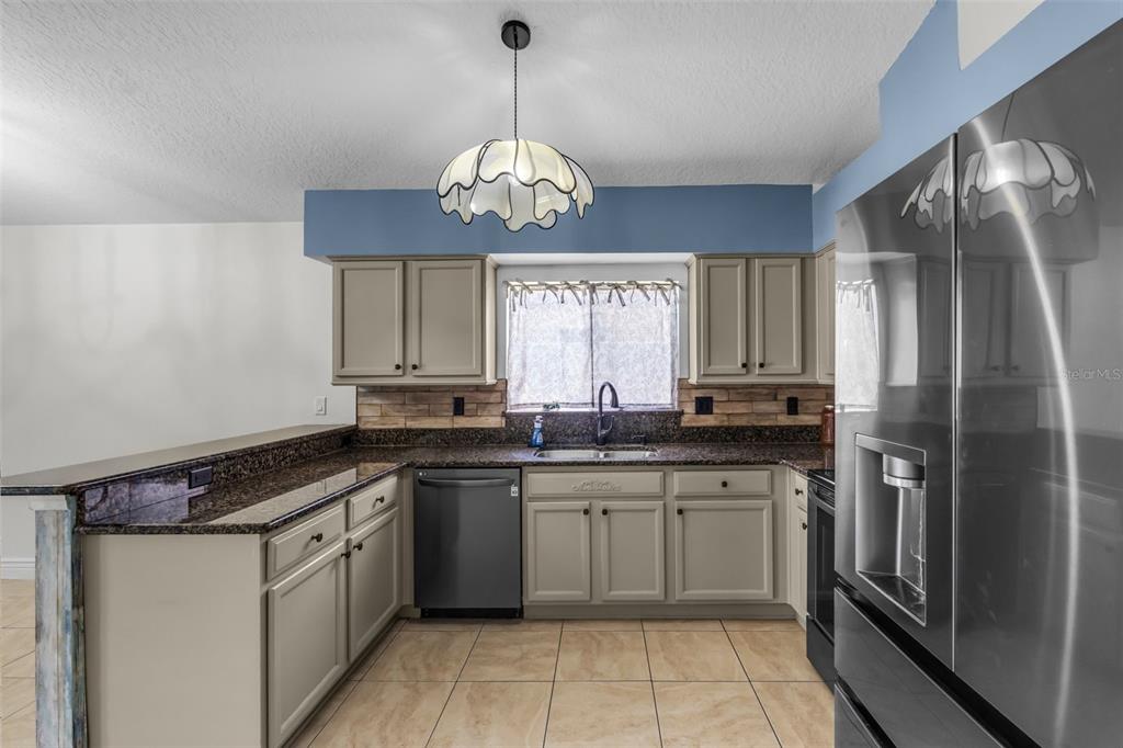 1424 Ocean Reef Road Wesley Chapel, FL 33544 - Photo 8 of 47 a kitchen with a sink refrigerator and microwave