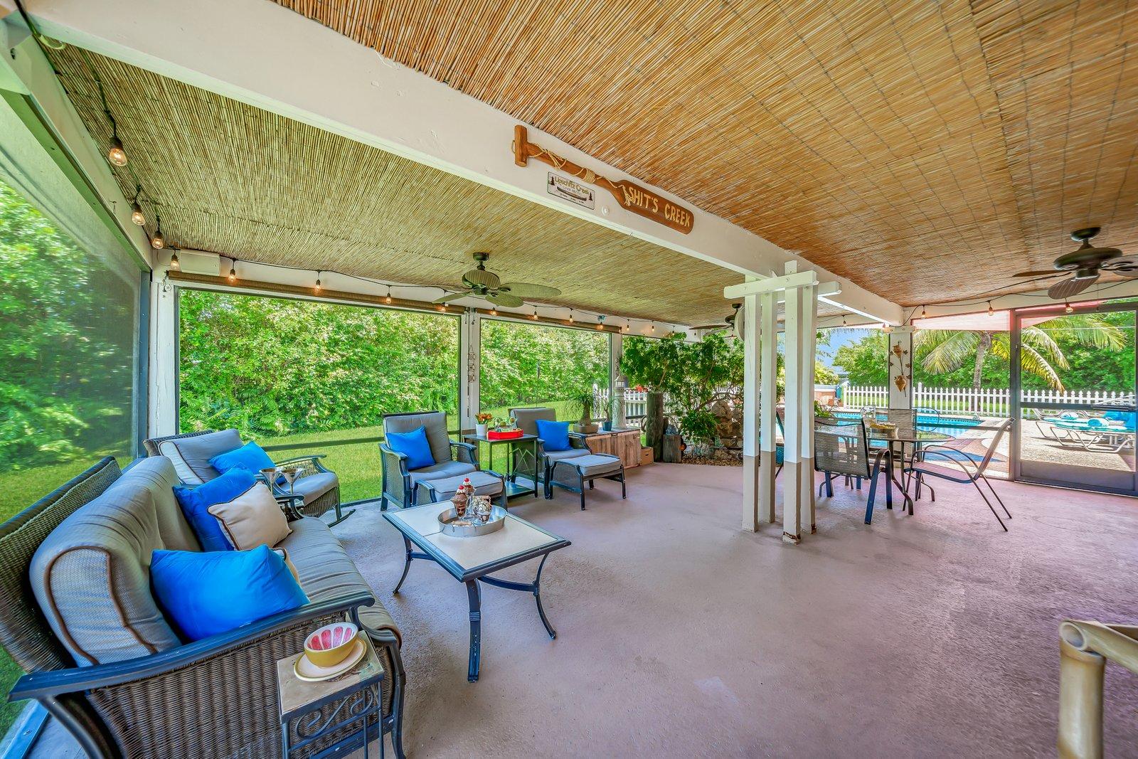22206 Aquila Street Boca Raton, FL 33428 - Photo 49 of 73 a view of a patio with table and chairs potted plants with floor to ceiling window