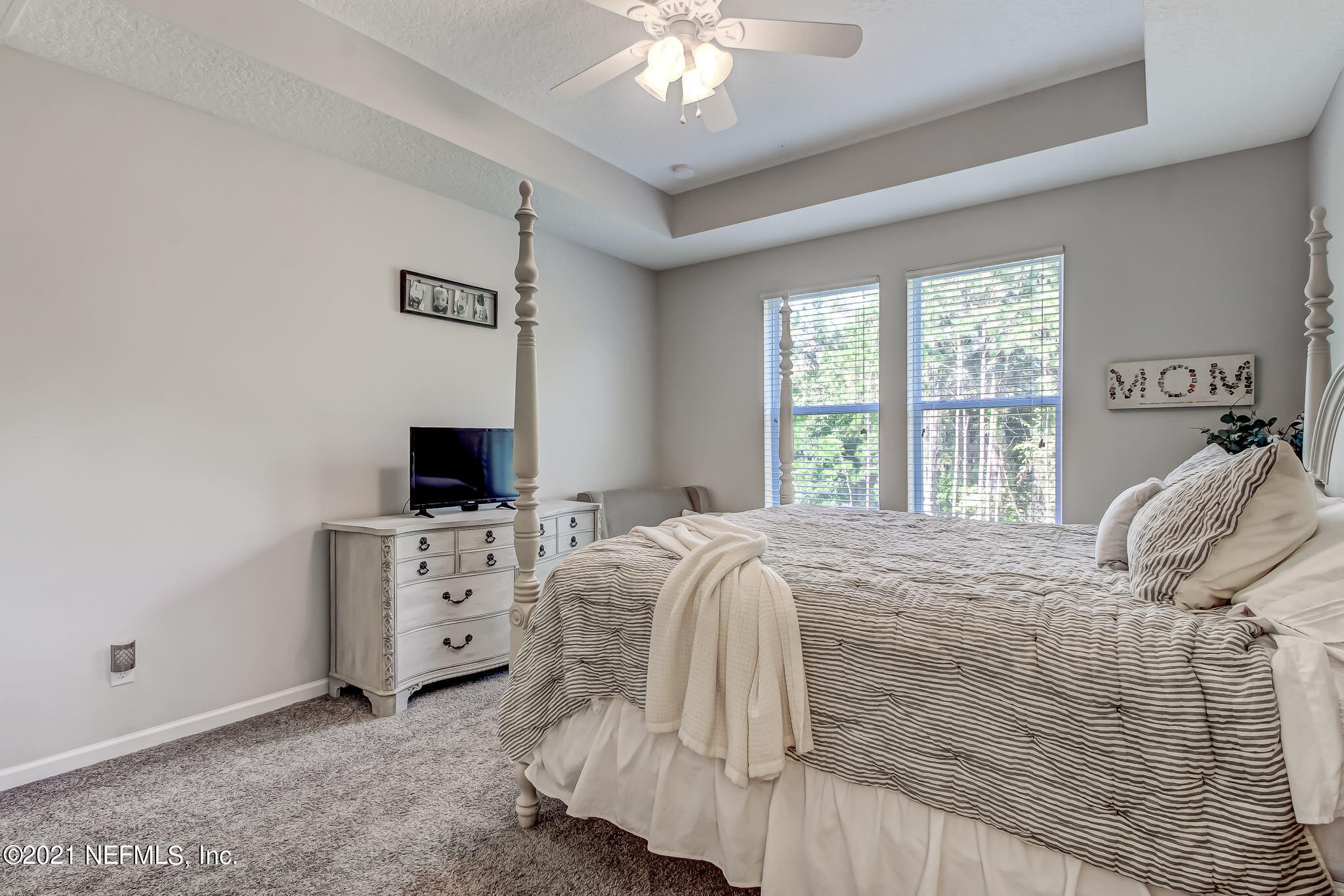 33 Adler Place St. Johns, FL 32259 - Photo 27 of 82 a bed sitting in a bedroom next to a window with a chandelier