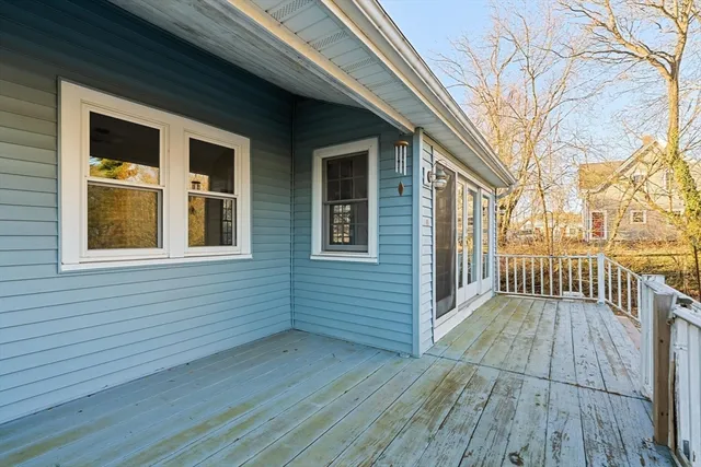 a view of a balcony with wooden floor and floor to ceiling window